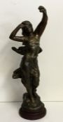 A spelter model of a lady with outstretched arms.