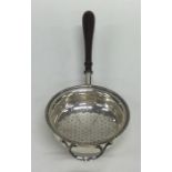 An Edwardian silver tea strainer with turned handl