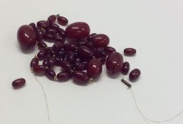 A bag containing tapering red amber beads. Approx.
