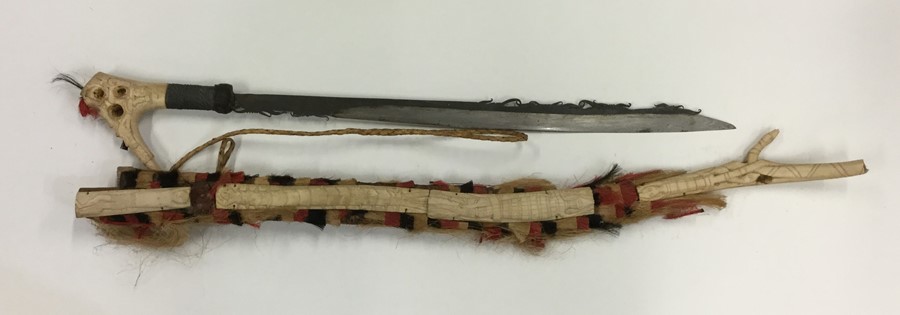 A 20th Century African tribal sword in sheath. Est
