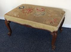 A Victorian upholstered stool on scroll feet. Est.