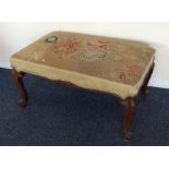 A Victorian upholstered stool on scroll feet. Est.