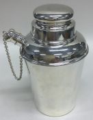 A dinky silver cocktail shaker with lift-off cover