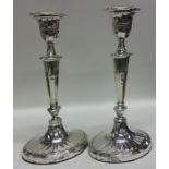 A pair of silver candlesticks with tapering stems.