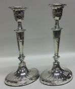A pair of silver candlesticks with tapering stems.