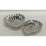 A matched pair of silver shell shaped dishes on ba