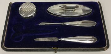 A cased part engine turned silver manicure set. Bi