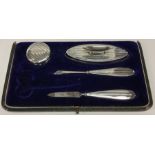 A cased part engine turned silver manicure set. Bi