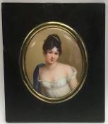 An oval porcelain miniature of a lady in white dre