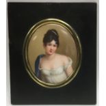 An oval porcelain miniature of a lady in white dre