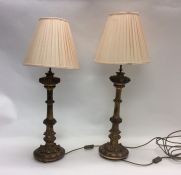 A pair of gilt bedside lamps with pink shades. Est