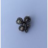 An unusual diamond brooch in the form of a clover