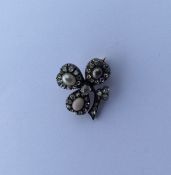An unusual diamond brooch in the form of a clover