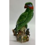 A tall pottery figure of a parrot in seated positi