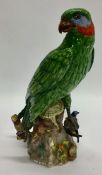 A tall pottery figure of a parrot in seated positi