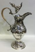 A massive silver ewer of swirl design with hinged