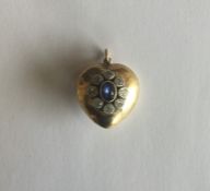 A large sapphire and diamond heart shaped locket w