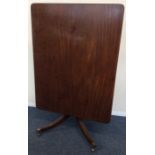 A mahogany rectangular tilt top breakfast table on