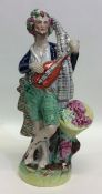 A tall Staffordshire figure of a gentleman playing