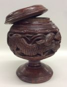 An Asian carved Treen tobacco box carved with anim