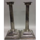 A pair of tall Georgian silver candlesticks with t