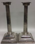 A pair of tall Georgian silver candlesticks with t