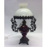 A brass mounted and red pottery table lamp with gl