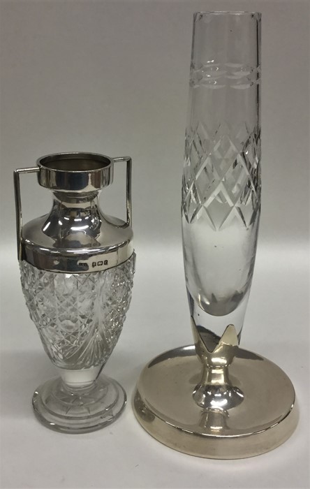 A silver and cut glass vase on circular spreading