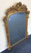 A large flamboyant gilt bevel edged mirror with sc