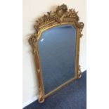 A large flamboyant gilt bevel edged mirror with sc
