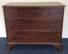 A mahogany chest of three drawers on bracket feet.