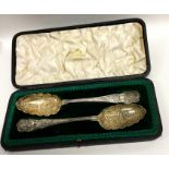 A cased pair of silver and silver gilt berry spoon
