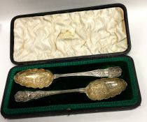 A cased pair of silver and silver gilt berry spoon