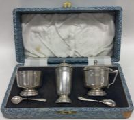 A boxed silver and engine turned three piece cruet