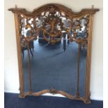 A massive gilt overmantle mirror with shaped top d