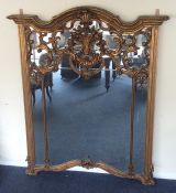 A massive gilt overmantle mirror with shaped top d