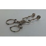 A small pair of silver scissor nips with ball deco