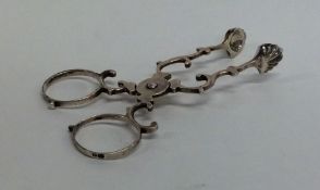 A small pair of silver scissor nips with ball deco