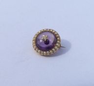 An attractive cabochon amethyst and diamond brooch