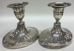 A pair of oval Edwardian silver fluted dwarf candl