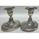A pair of oval Edwardian silver fluted dwarf candl
