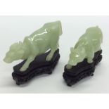 A graduated pair of carved hard stone oxen on wood