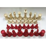 A carved ivory chess set with tapering stems. Est.