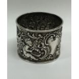 A heavy silver embossed napkin ring decorated with