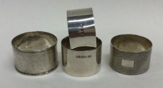 A group of four silver napkin rings. Various dates