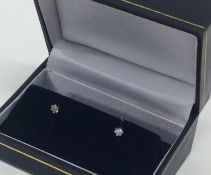 A pair of small diamond single stone ear studs in