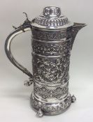 A tall flamboyant silver beer jug embossed with fl