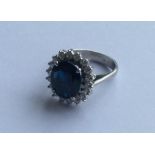 A sapphire and diamond oval cluster ring in 18 car