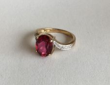 A 9 carat diamond and red stone crossover ring in