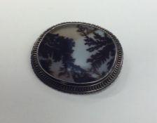 A moss agate and silver oval brooch in pierced fra